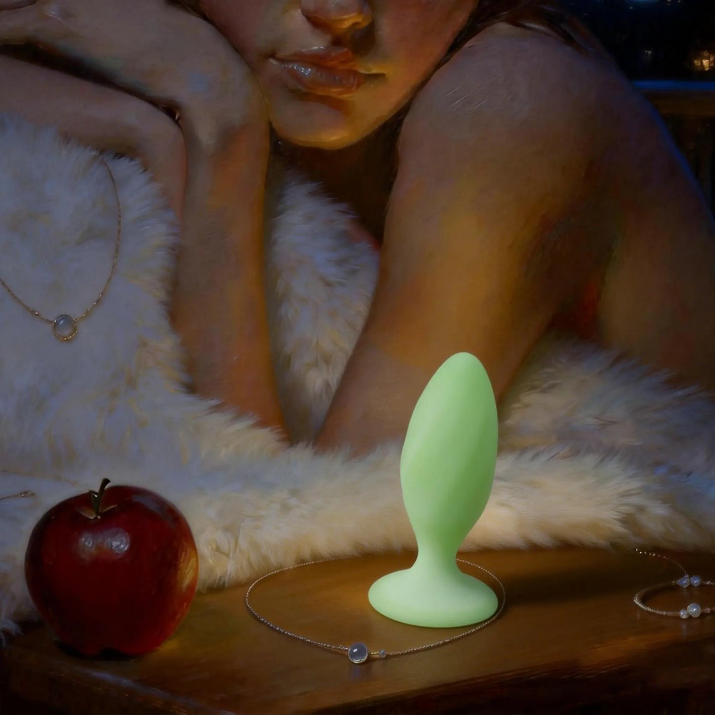 Green silicone butt plug on a wooden surface with an apple and a person in the background.